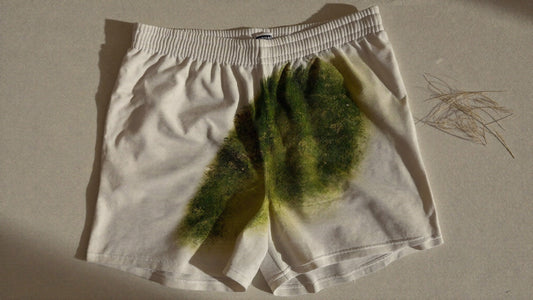 Mancha de pasto en short deportivo blanco